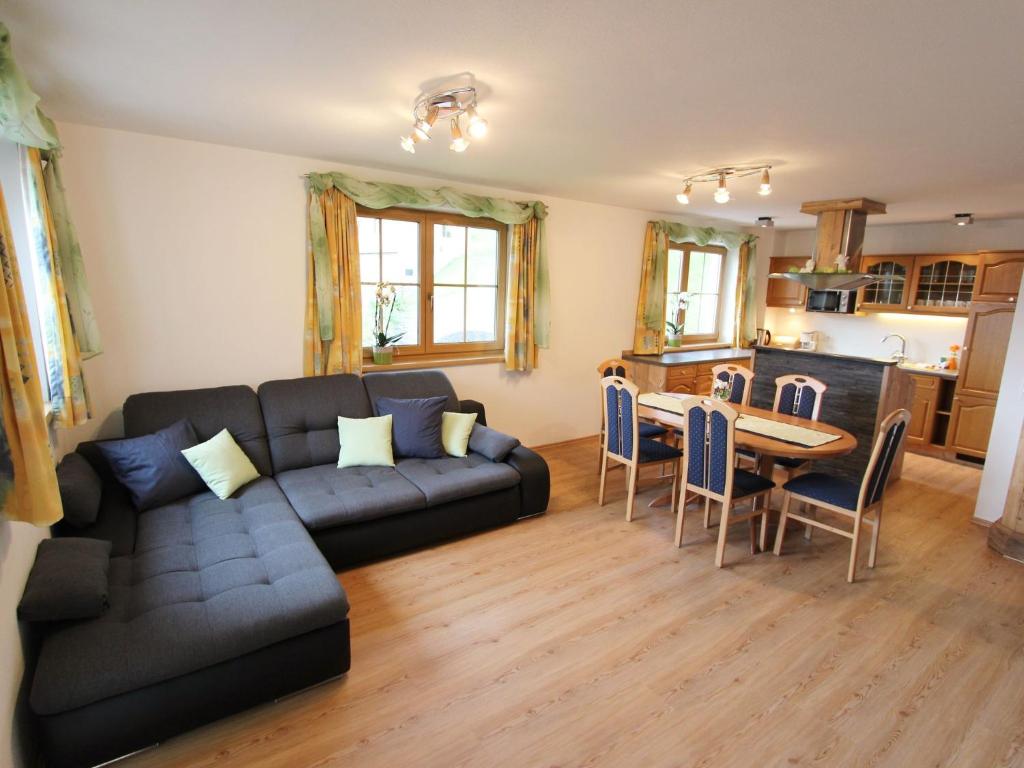 ein Wohnzimmer mit einem Sofa und einem Tisch in der Unterkunft Cosy holiday flat in a farmhouse in Taxenbach