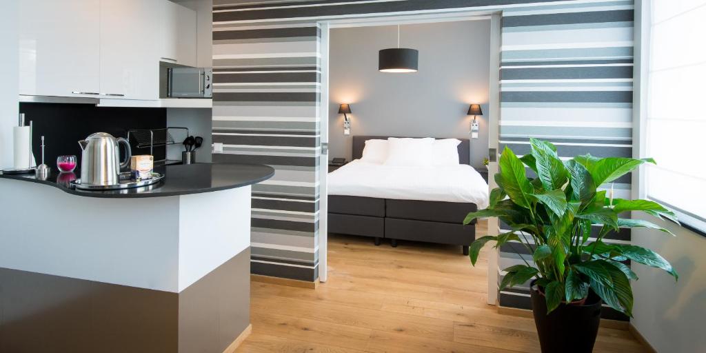 a hotel room with a bed and a kitchen at B&B Avenue Deschanel in Brussels