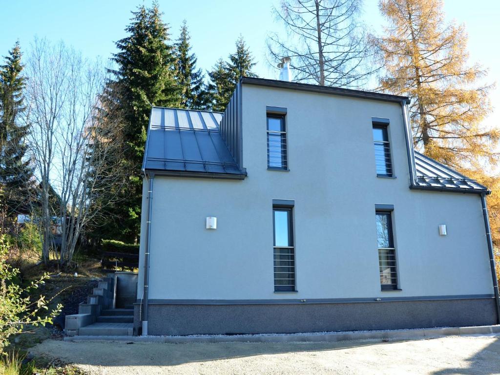 a white house with a solar panel on it at Quaint Holiday Home in elezn Ruda near Ski Area in Železná Ruda