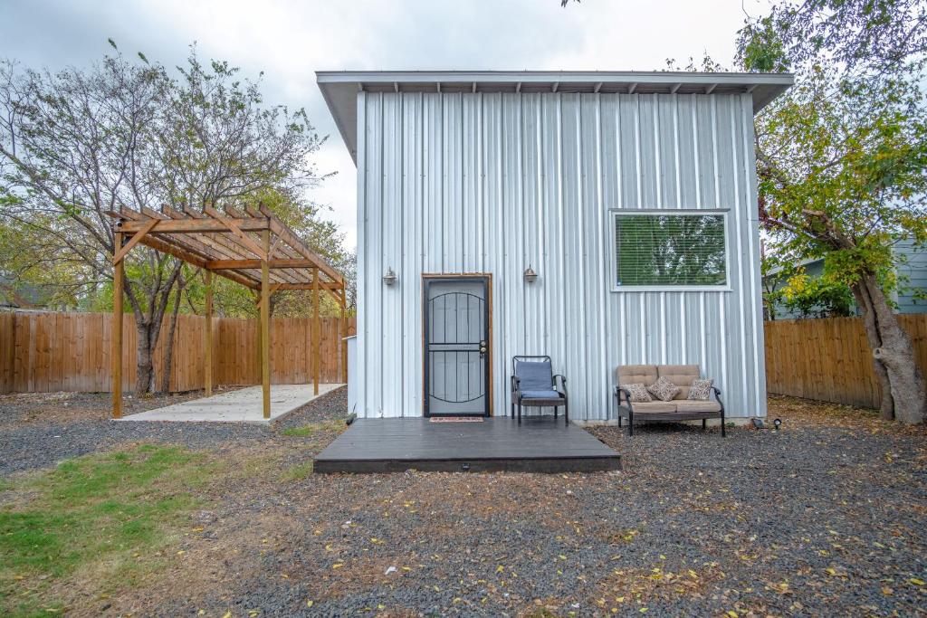 a white shed with a couch and a chair at Guest House with Loft Near Downtown in San Antonio