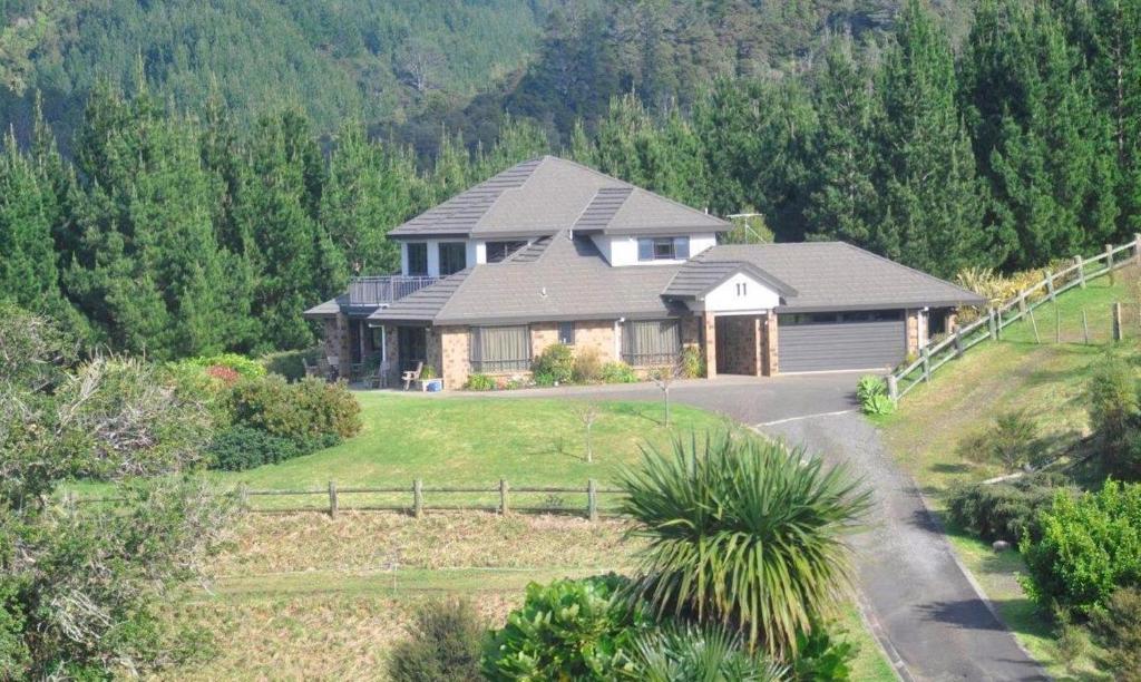 a house on a hill with a driveway at Ohuka Place Homestay in Whitianga