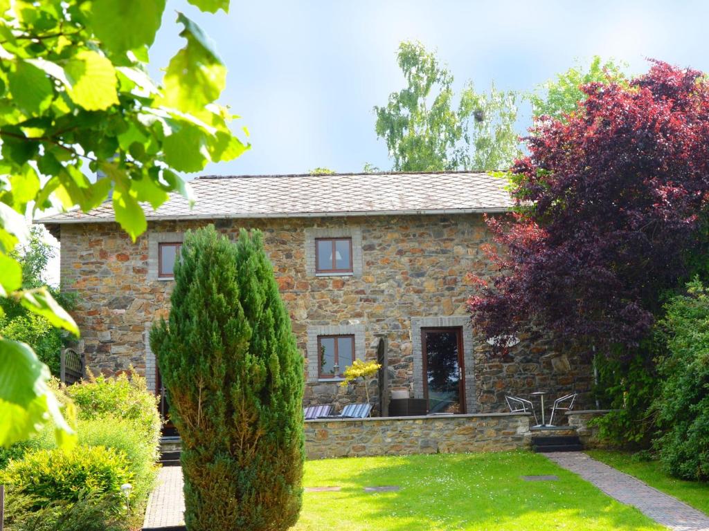 a stone house with a garden in front of it at Charming Cottage in Stoumont with colourful garden in Exbomont