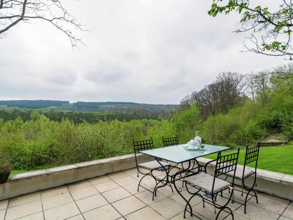 a table and chairs on a patio with a view at Perfect spot on the edge of a large wood in Awenne