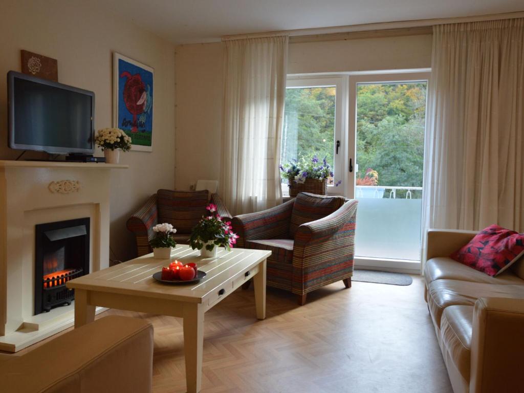 a living room with a couch and a fireplace at Holiday home in nice surrounding in Veldenz