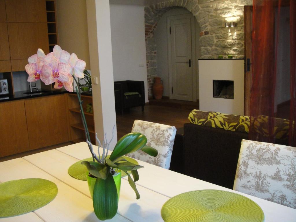 a dining room table with a vase of flowers on it at Old Town Apartment in Tallinn