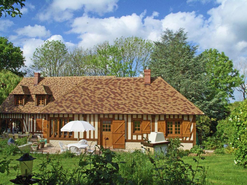 a large wooden house with a roof at Traditional house with garden in Dampsmesnil in Écos