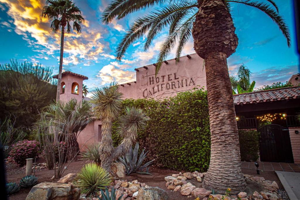 uma palmeira em frente a um edifício com uma placa em Hotel California em Palm Springs