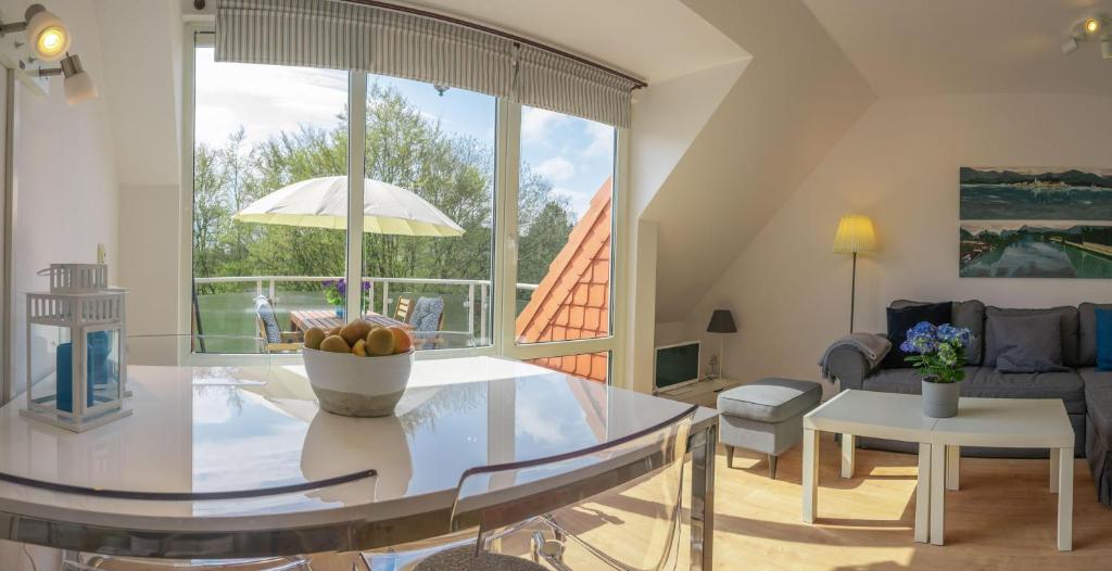 - un salon avec une table et une grande fenêtre dans l'établissement Urlaubsfeeling-in-der-Captains-Suite-App-18, à Timmendorfer Strand