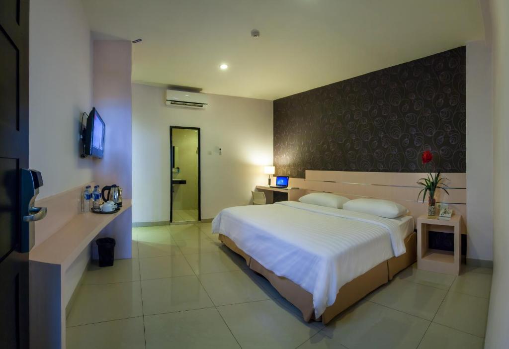Tempat tidur dalam kamar di Cordela Hotel Medan