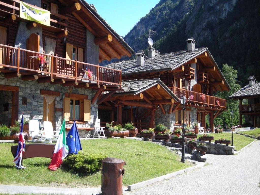 a log cabin with flags in front of it at Belvilla by OYO GrBe Bilo in Antey-Saint-André