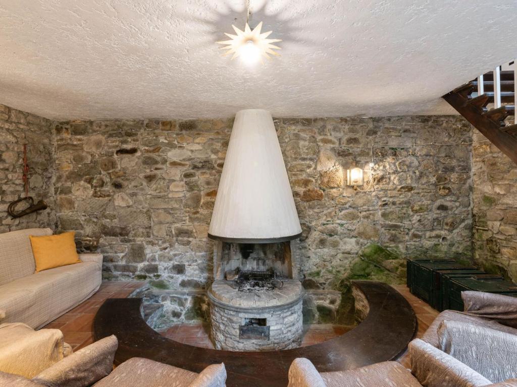 sala de estar con pared de piedra y chimenea en Belvilla by OYO Bellona, en Migliorini
