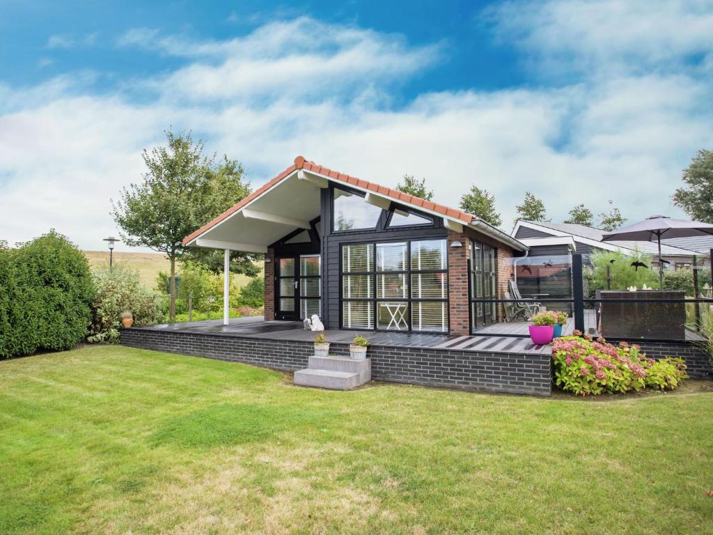 a small house with a lawn at Attractive holiday home with large terrace in Kattendijke