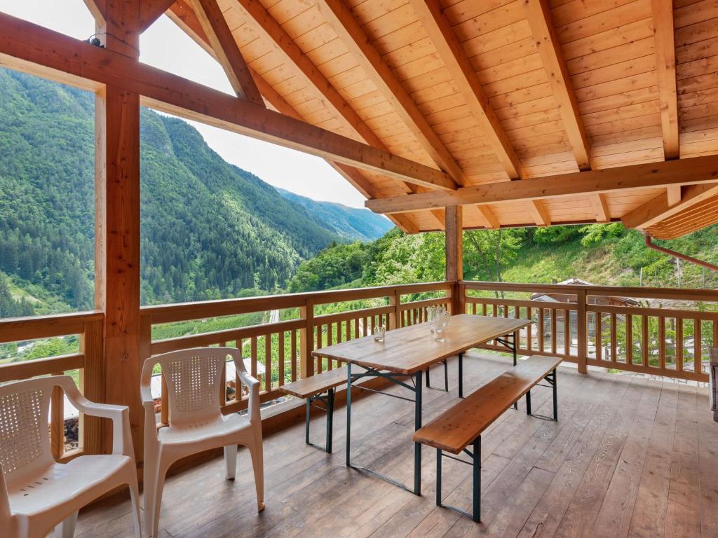 einen Tisch und Stühle auf einer Terrasse mit Bergen im Hintergrund in der Unterkunft Belvilla by OYO Il melo bianco in Caldes
