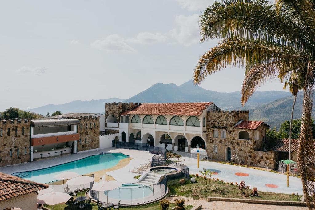 een uitzicht op het zwembad in een resort met een palmboom bij Hotel El Castillo Chinauta in Chinauta