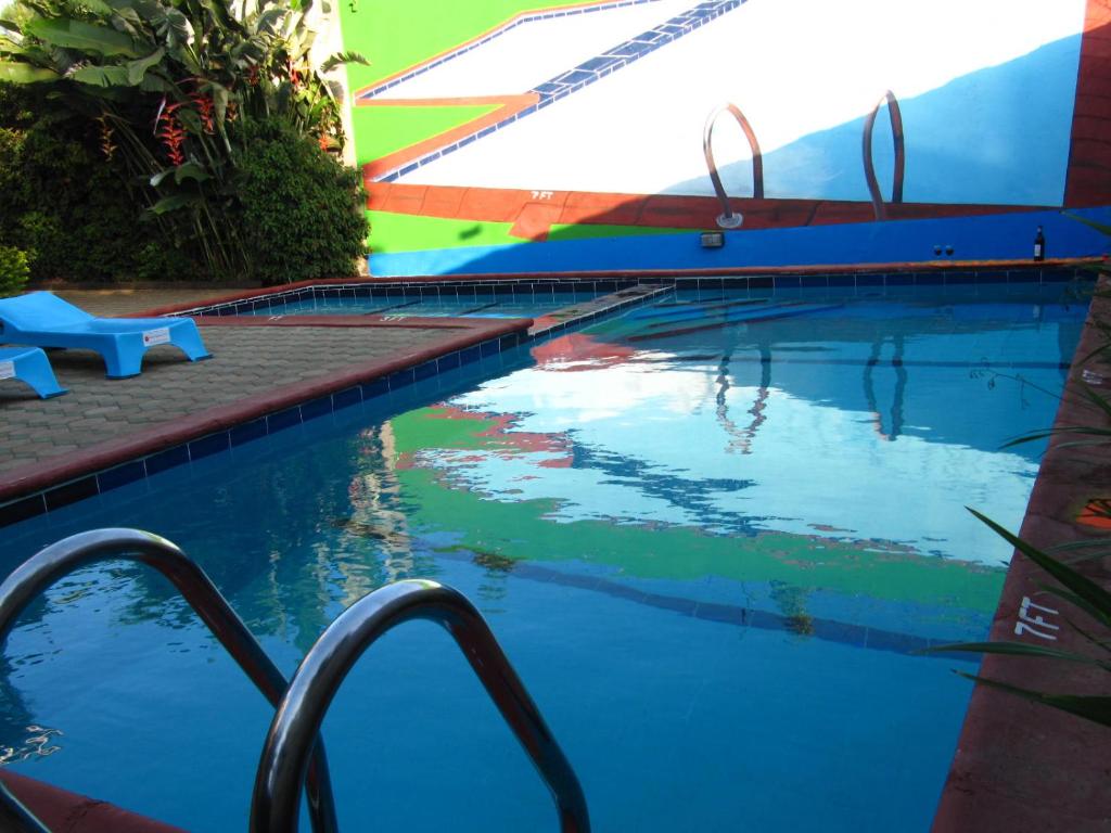 a swimming pool with a reflection of the sky in the water at Korona House Hotel in Arusha