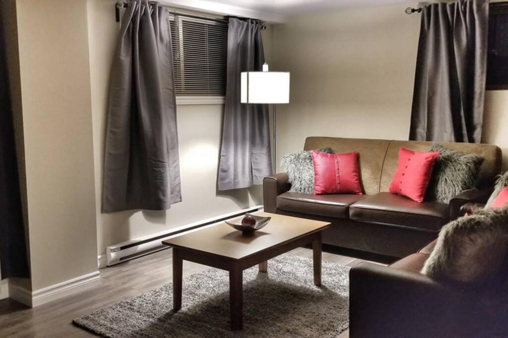 een woonkamer met een bank en een salontafel bij Cozy Spacious 2 Bedroom basement Apt by Amazing Property Rentals in Gatineau