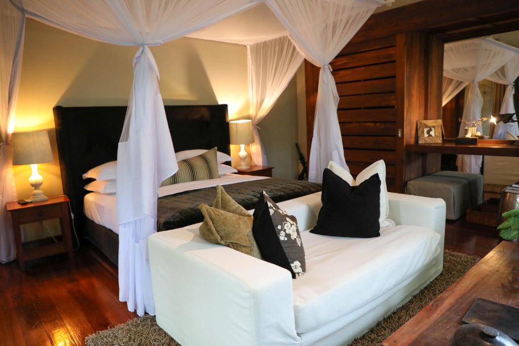 Nkoanrua的住宿－Lake Duluti Lodge Arusha，一间卧室配有两张床和一张白色沙发