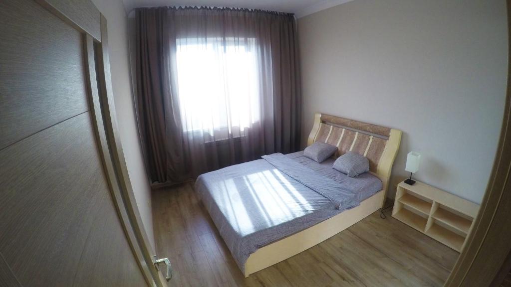 a small bedroom with a bed and a window at Просторная квартира в Одессе in Odesa