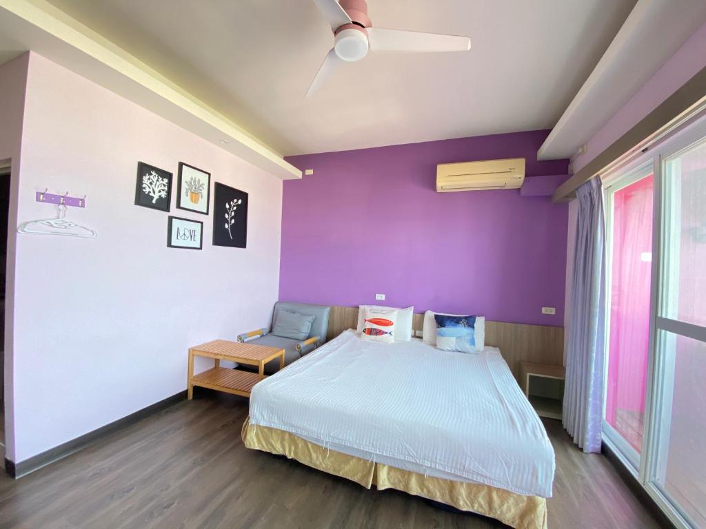 a bedroom with purple walls and a bed and a chair at I WoW in Xiaoliuqiu
