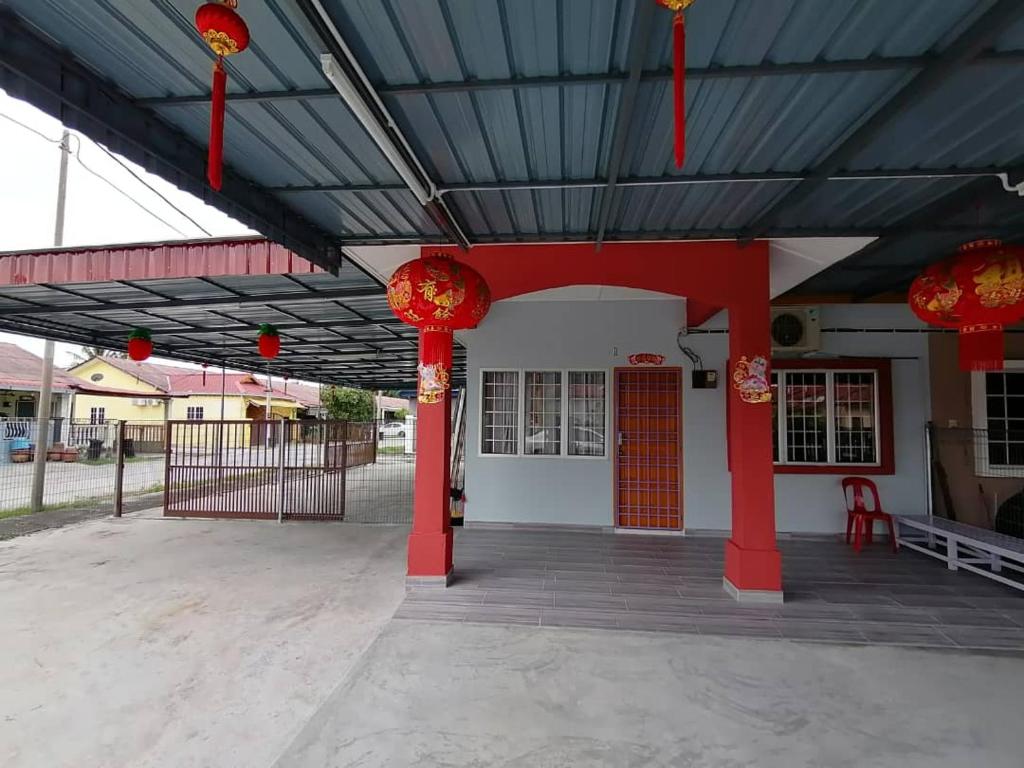 a building with red columns and red lanterns on it at Mui Gim Homestay 大港 美景民宿 in Sungai Besar