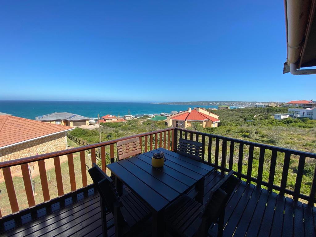 uma mesa numa varanda com vista para o oceano em Relax & Recharge em Boggomsbaai