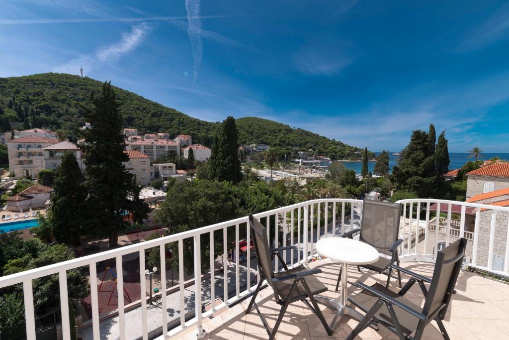 een balkon met een tafel en stoelen en uitzicht op de stad bij Hotel Perla in Dubrovnik