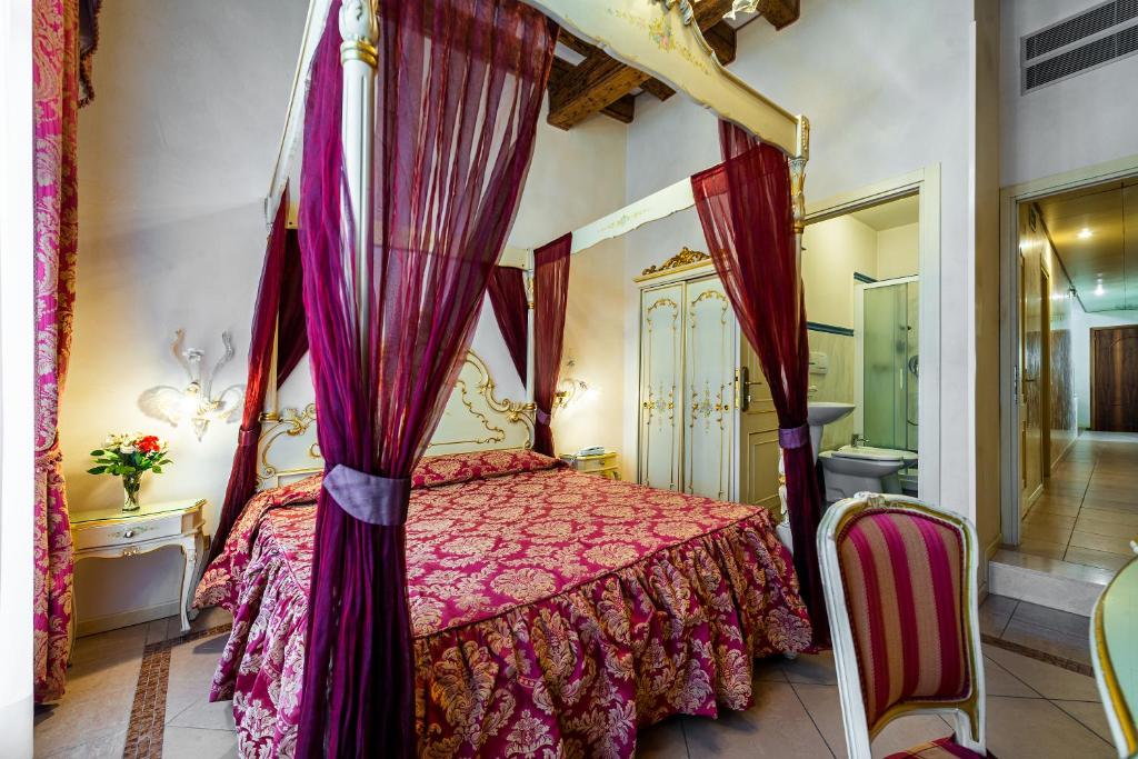 ヴェネツィアにあるホテル アル ヴァゴンのベッドルーム(天蓋付きベッド1台、バスルーム付)