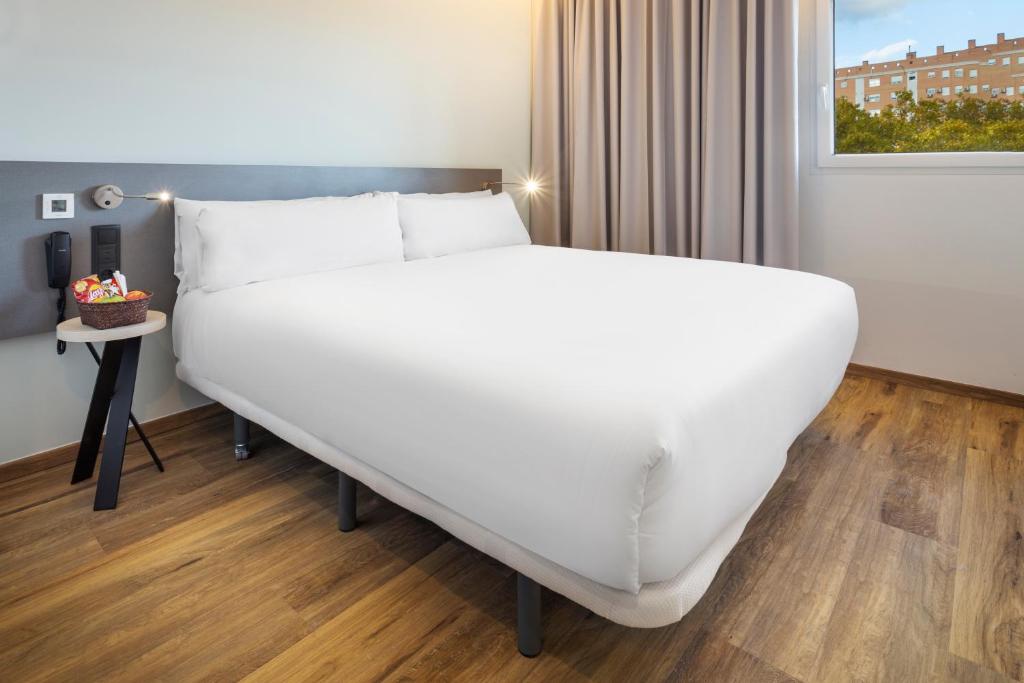 uma grande cama branca num quarto com uma janela em B&B HOTEL Madrid Alcorcón em Alcorcón