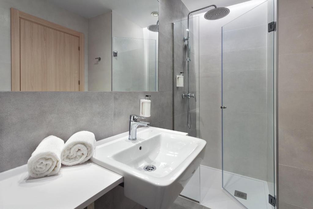 Un baño blanco con lavabo y ducha. en B&B HOTEL Madrid Alcorcón, en Alcorcón