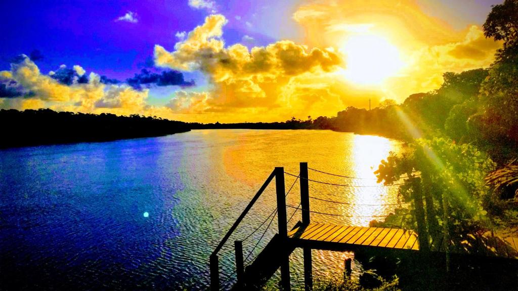 a view of a river with the sun setting at Casinha Amarela Chales Boipeba in Ilha de Boipeba