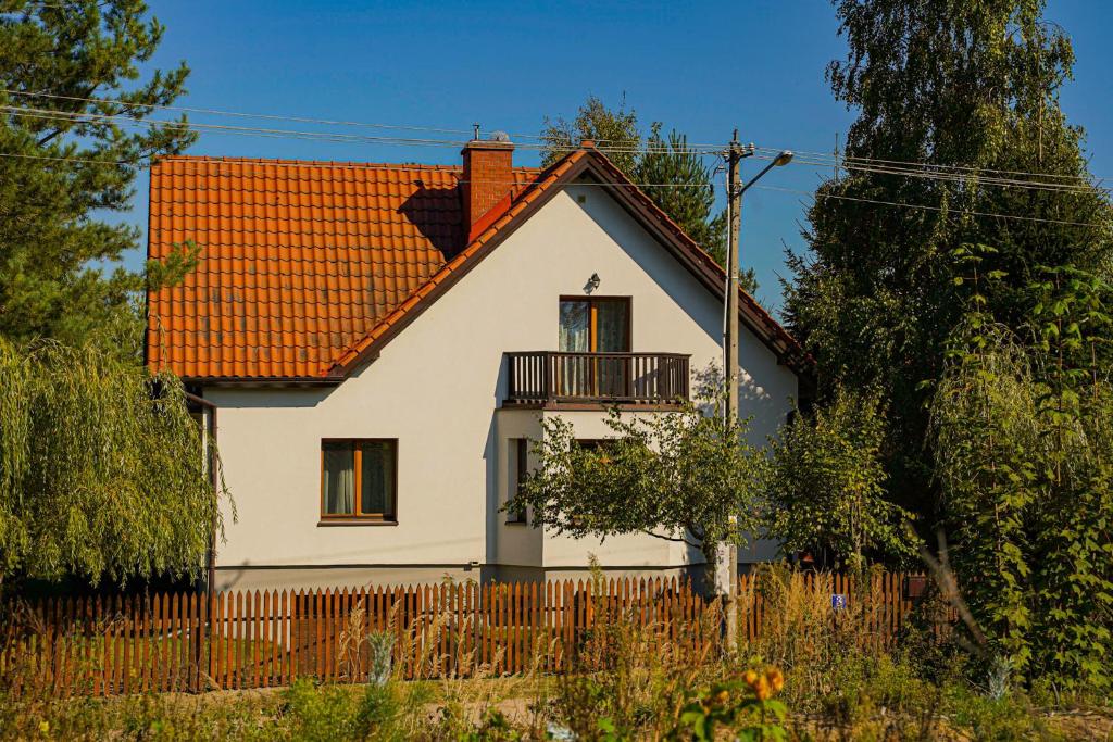a white house with an orange roof at Leśne zacisze in Rydzewo