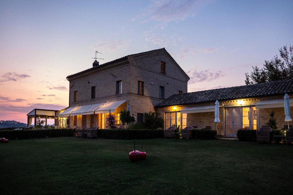 un gran edificio blanco con luces encendidas al atardecer en Casa San Ruffino, en Montegiorgio