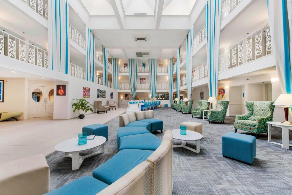 a large lobby with blue chairs and tables at The Blu Hotel Blue Ash Cincinnati, Ascend Hotel Collection in Blue Ash