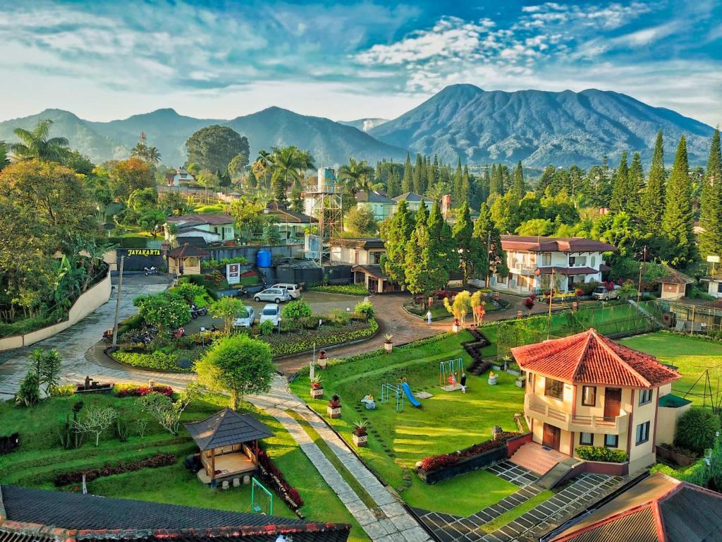 una vista aérea de una pequeña ciudad con montañas en el fondo en The Jayakarta Cisarua, en Puncak