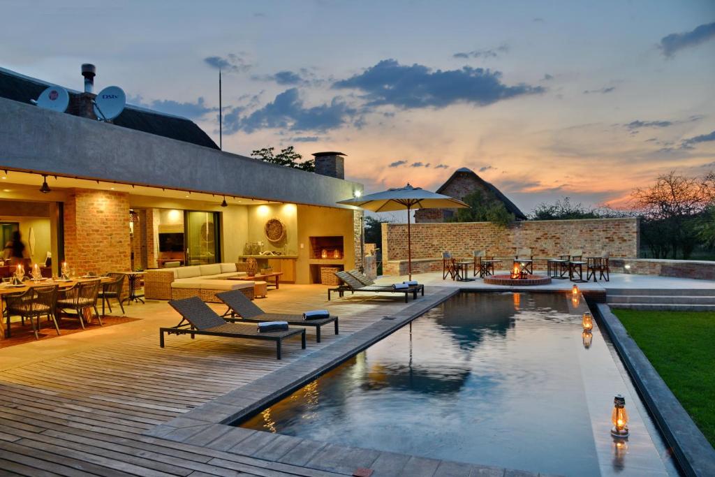 a backyard with a swimming pool and a patio at Ngala Lodge in Klipdrift