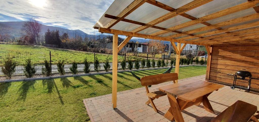 a wooden patio with a table and a view of a field at Domek w Karkonoszach 2 in Ściegny