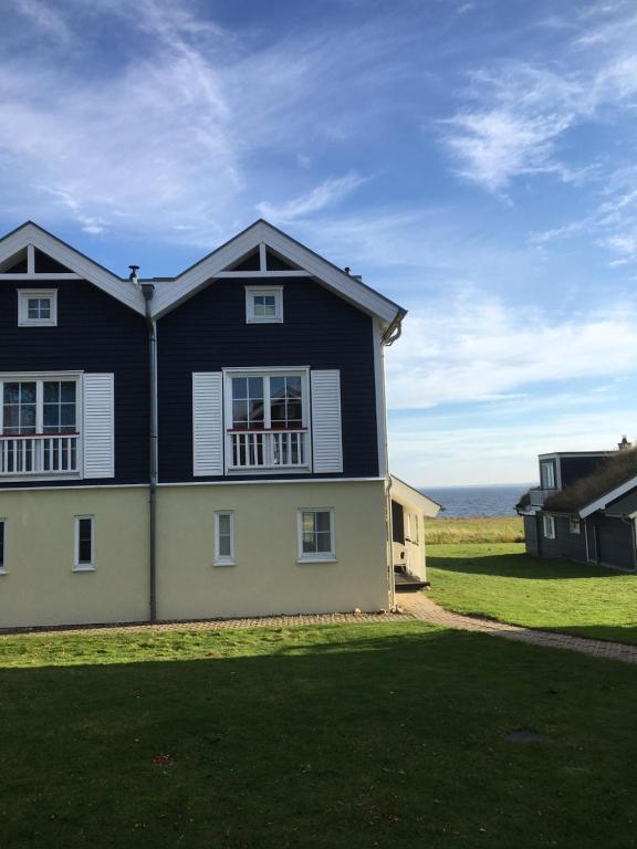 ein schwarzweißes Haus mit dem Ozean im Hintergrund in der Unterkunft Ferienhaus Oceanview in Sierksdorf