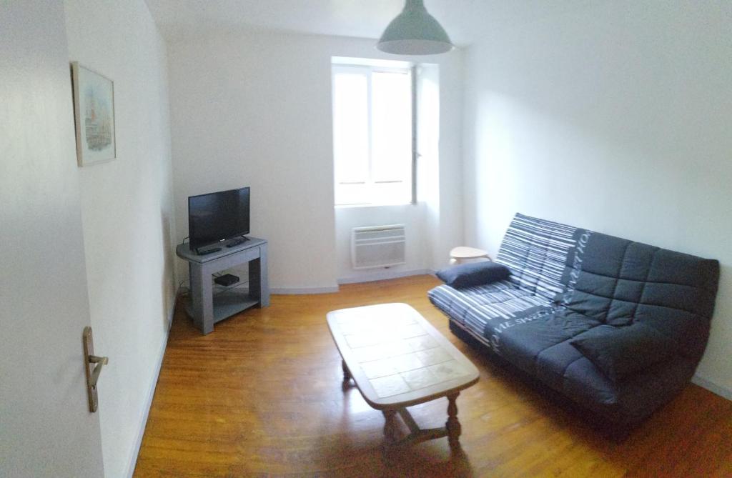 sala de estar con sofá y TV en la violette, en Ferrières-Saint-Mary