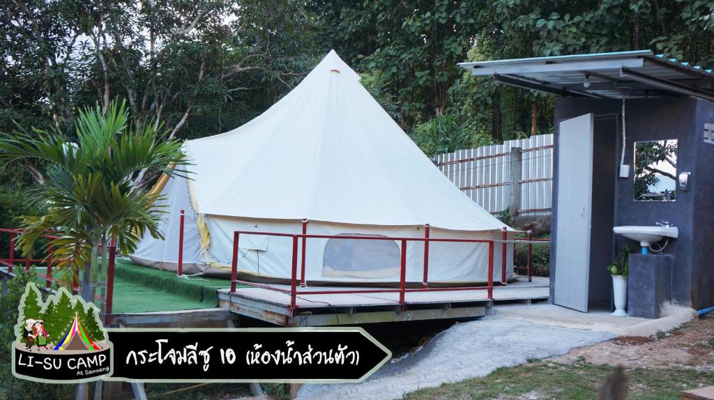 une grande tente blanche dans une cour à côté d'un bâtiment dans l'établissement Li-su Camp at Samoneng, à Samoeng