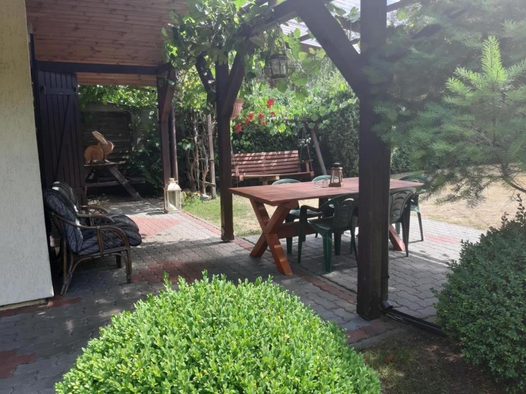 patio con tavolo in legno e panca di domek letniskowy w Kujankach a Kujan