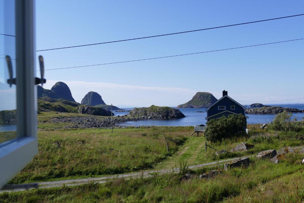 una casa en la orilla de un cuerpo de agua en Koselig Hytte mellom sjø og fjell, en Nykvåg