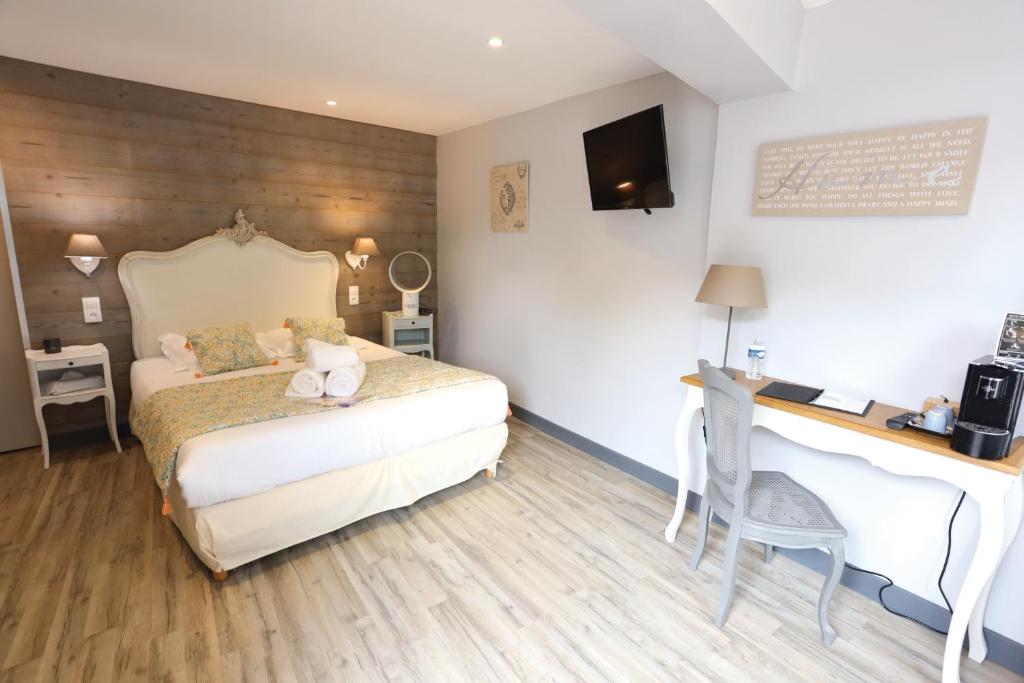 Schlafzimmer mit einem Bett, einem Schreibtisch und einem Schreibtisch in der Unterkunft Hôtel de charme Le Sens in Vaux-sur-Mer