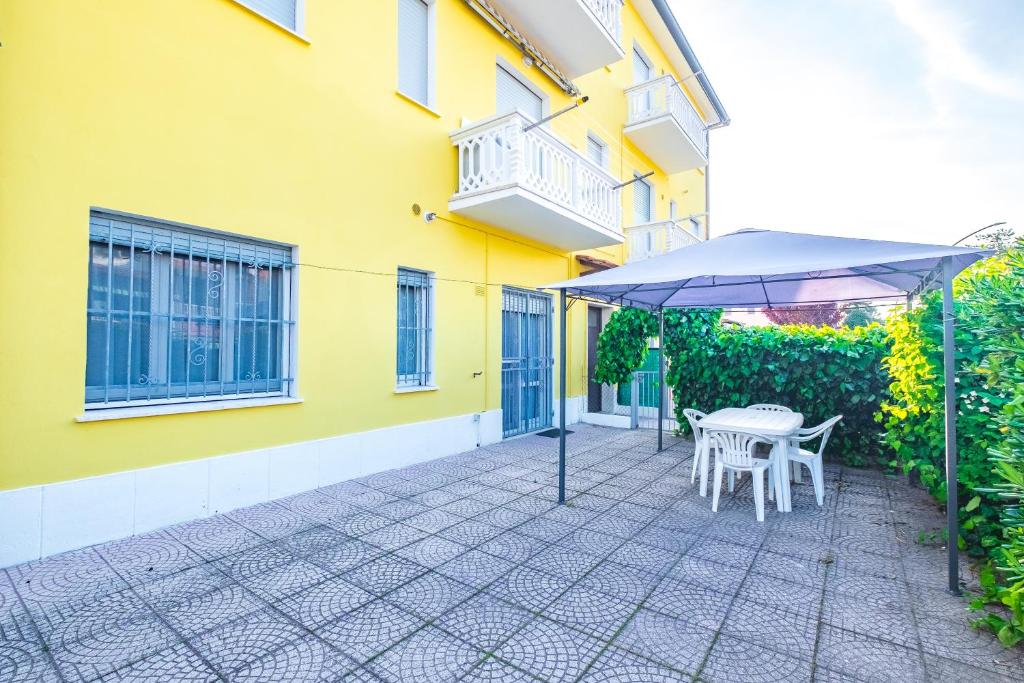 een patio met een parasol en een tafel en stoelen bij Agenzia Vear Villa Marina in Lido delle Nazioni