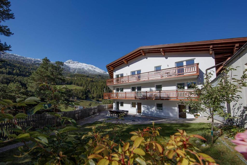 a large building with a balcony and mountains in the background at Apart Mount Everest in Sölden