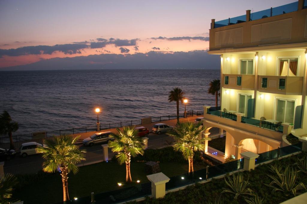 um edifício com vista para o oceano à noite em Gardenia Hotel em Lazzaro