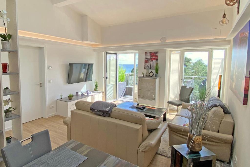 ein Wohnzimmer mit einem Sofa und einem Tisch in der Unterkunft Loftappartement Sundowner mit fantastischem Meerblick in Prora in Binz