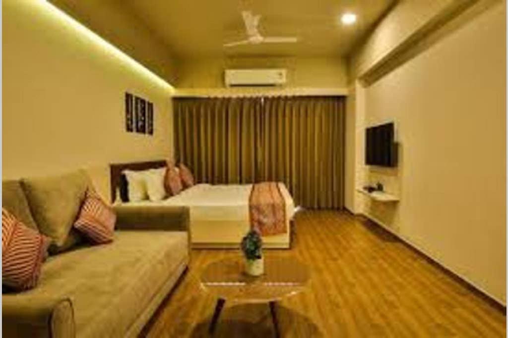 a living room with a couch and a bed at Studio Stays in Surat