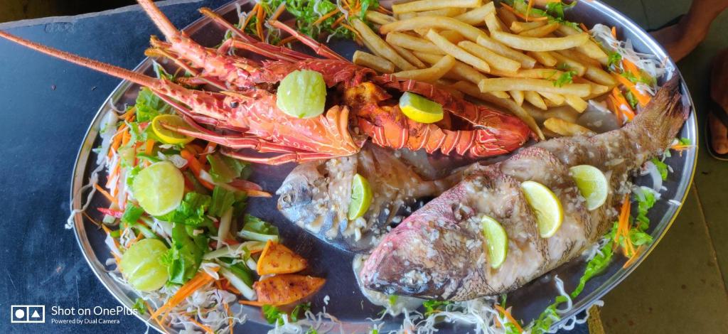 a plate of food with seafood and french fries at Rococo Pelton beach huts Palolem Beach goa in Palolem