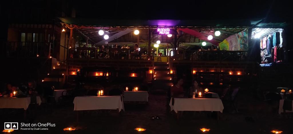 a restaurant at night with candles on tables at Rococo Pelton beach huts Palolem Beach goa in Palolem