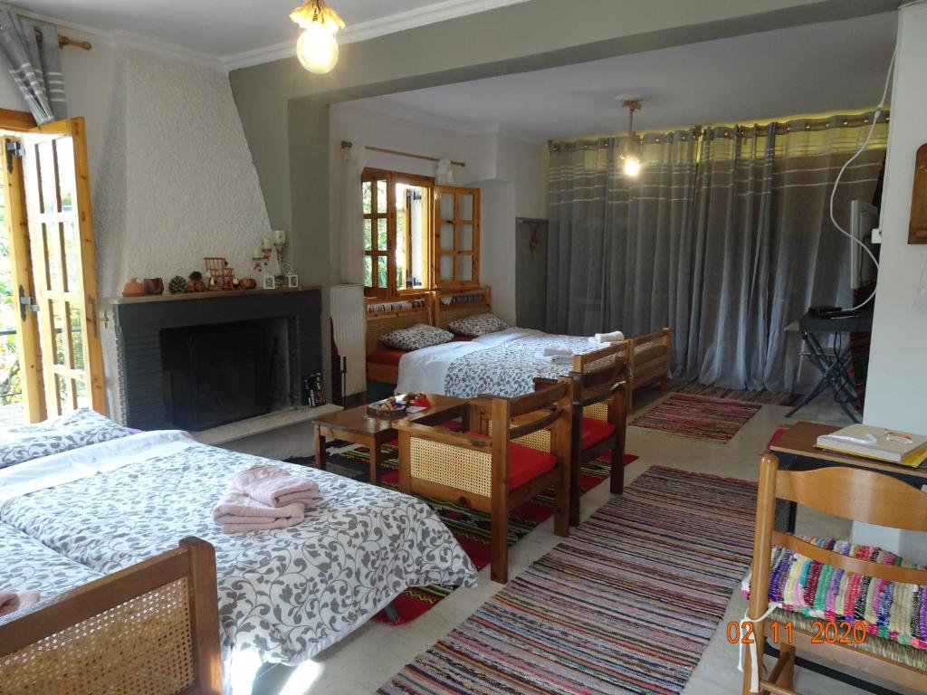 a bedroom with two beds and a table and a fireplace at Vitina's little house in Vitina
